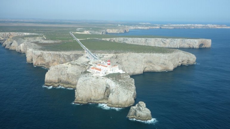 Cabo San Vicente, en bonanza. Al fondo la Ponta de Sagres. (Fotografía de autor desconocido, obtenida del archivo del portal de fotografía aérea de Portugal.)